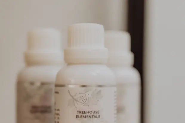 treehouse-white-bottles-of-Treehouse-Elementals-anti-aging-face-and-body-oil-labeled-pure-heart-with-Bulgarian-rose-oil-on-a-wooden-surface